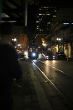 A streetcar on rail lines in New Orleans at night.