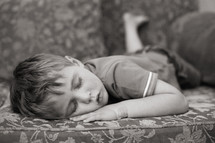 a child sleeping on a couch 