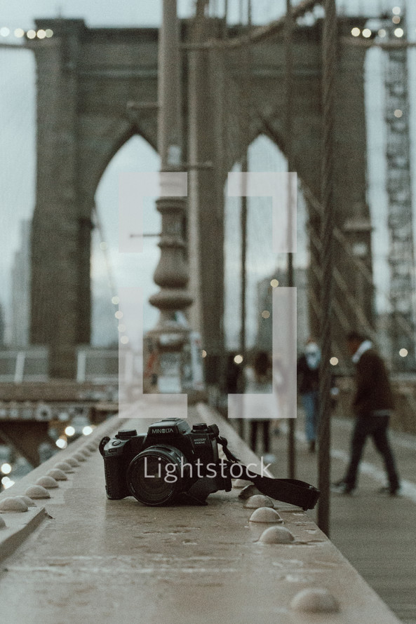 camera sitting on a railing of a bridge in New York City 
