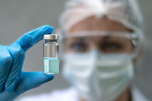 scientist holding a syringe and vaccine vial. Global alert. Vaccination. Covid-19. Coronavirus. Research.