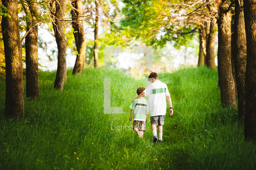 brothers walking through green grass 