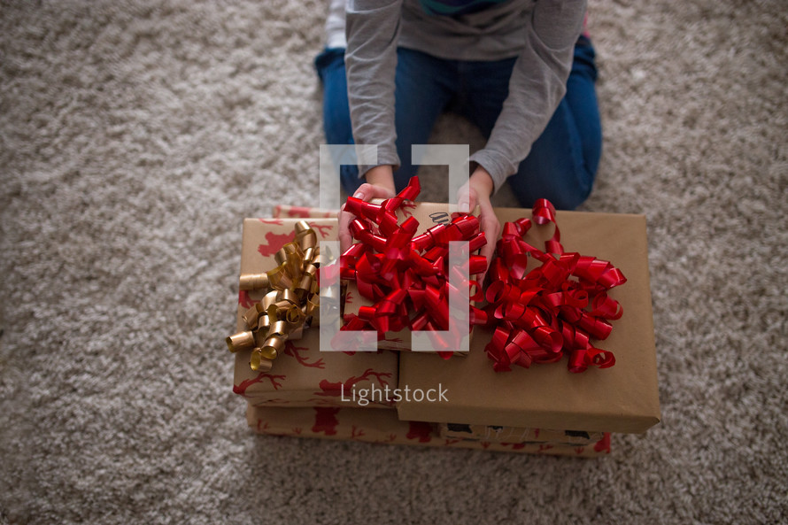 a boy sitting on the floor with Christmas presents 