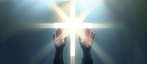 Hands towards christian glowing cross against blue background 