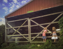 girls standing near a barn 