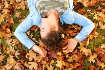 girl lying in fall leaves 