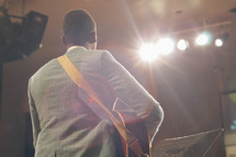 back of a man at the altar with a guitar 