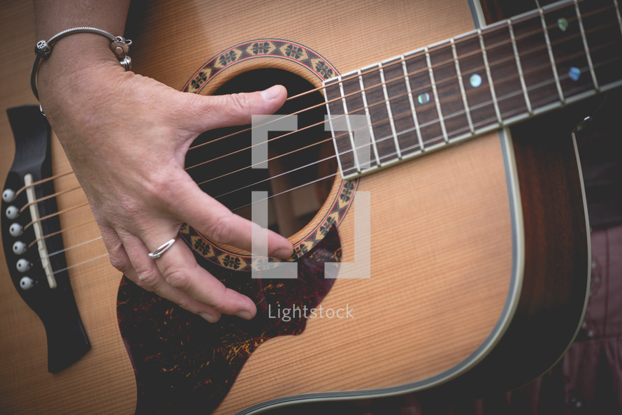 woman's hands on a guitar 