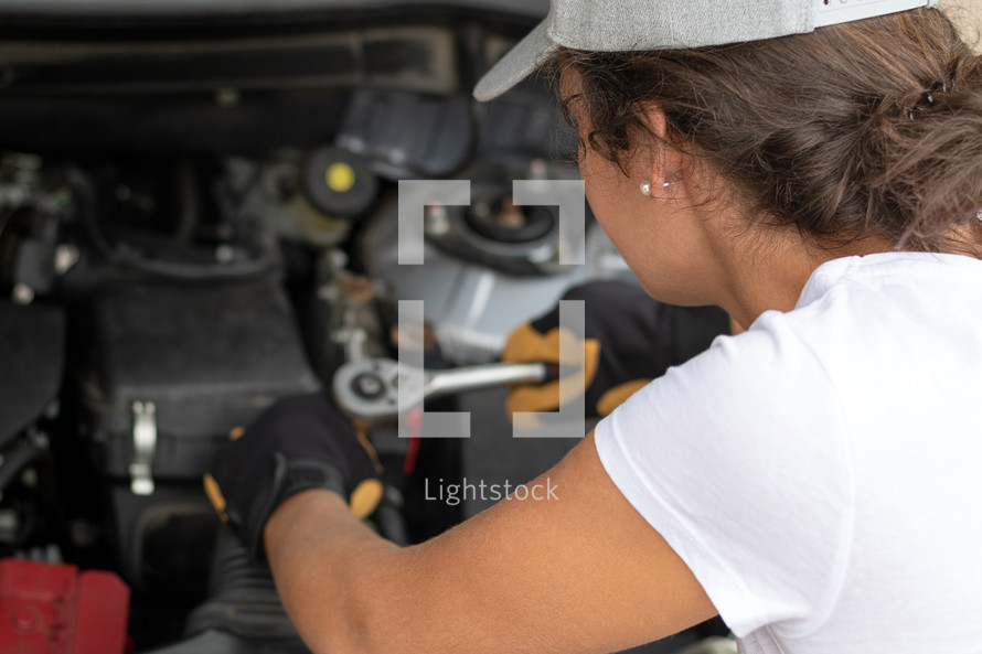 woman working on a car engine 