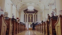 Communion or the Eucharist at a catholic church during a ceremony with a crucifix of Jesus in the center.