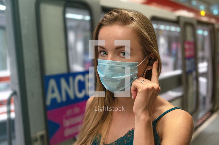 young woman in the subway wearing a mask 
