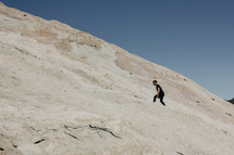 man walking up a mountainside 