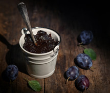 Bucket Of Thick Plum Jam on wooden table
