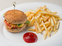 Big burger with french fries and ketchup on white plate. Fast food. Unhealthy dish.
