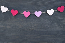 string of paper hearts on wood 