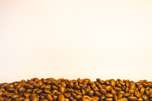 Bunch of coffee beans on a table with a light background.