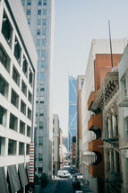 narrow street between tall buildings in a city 