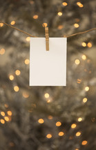 A blank notecard hanging on a line with a clothespin.