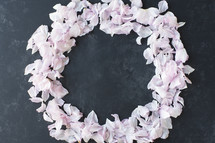 circle of pink rose petals on gray slate 