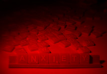 Red light shining on games tiles spelling "anxiety."