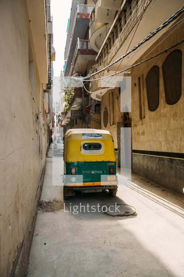 city alleyway in India with a tuk tuk