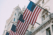 American flags on flag poles on a building 