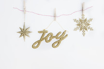 joy and snowflake ornaments on a white background 