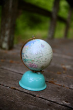 globe on a weathered boardwalk 