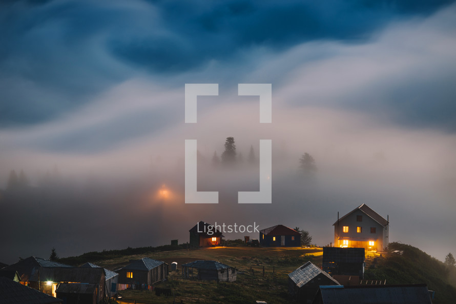 Misty and foggy mountain village in the evening