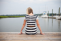 woman sitting at the end of a dock 