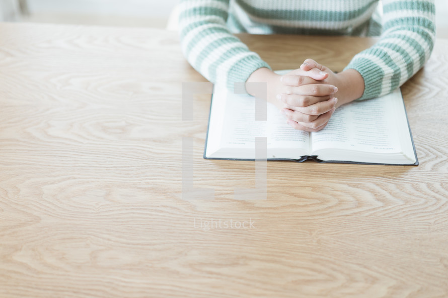 woman praying over an open Bible 