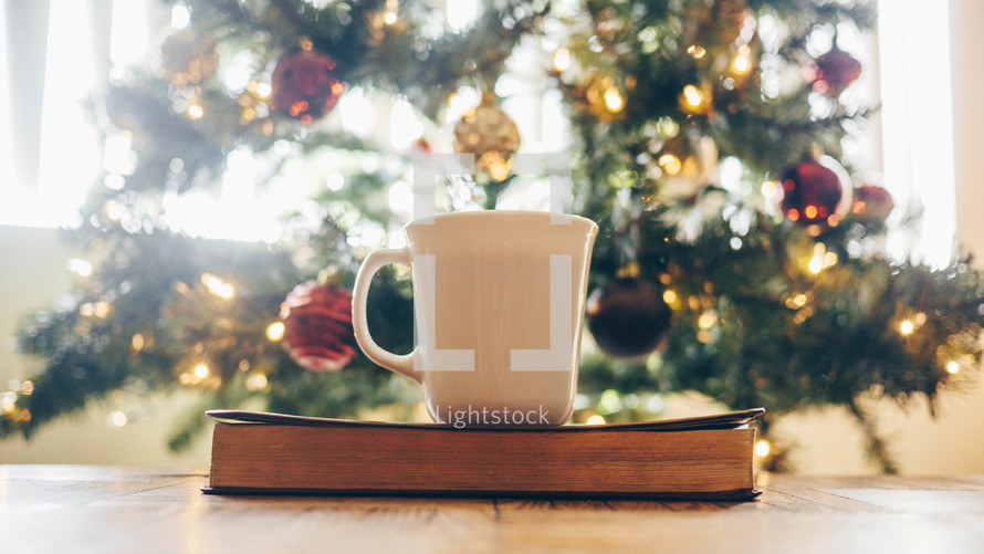 coffee mug on a Bible in front of a Christmas tree 