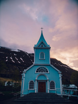 a blue church at sunset 