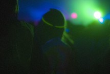 people in a crowd under stage lights 