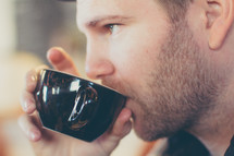 a man drinking from a mug 