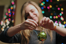 a woman a putting a hook on a Christmas ornament 