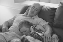 father and daughter asleep on the couch after a long week 