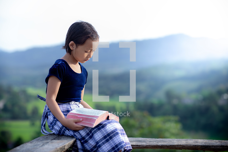 a school girl reading a Bible 