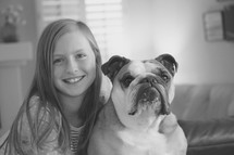 a little girl posing with her pet bulldog 