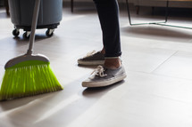 woman with a broom sweeping 