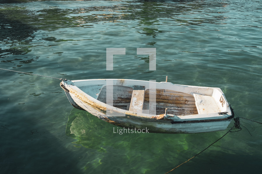 empty boat tied to a shore 
