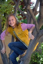 a preteen girl climbing a tree