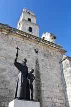 monk statue and church steeple 