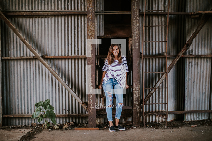 a young woman standing in a barn 