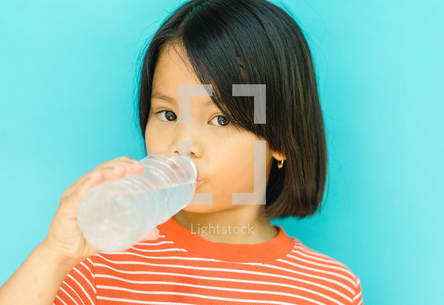 girl drinking from a water bottle 