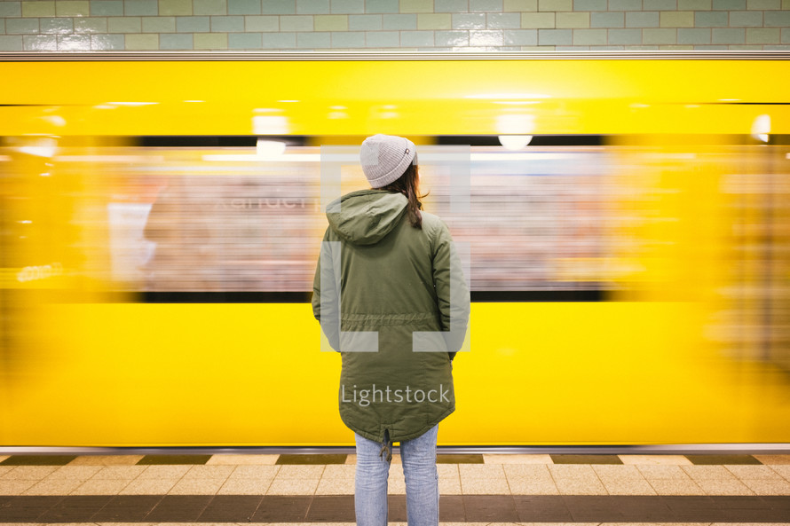 woman standing in front of a passing subway train 