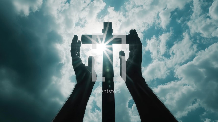 Silhouette of hands and a cross against blue sky with white clouds