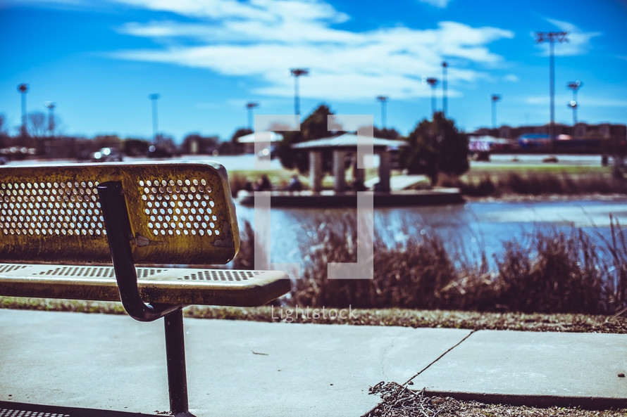 park bench with a view of a pond 