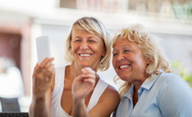 Modern mature women making happy mobile selfie