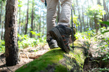Man walking on a log,hikers on their adventure in forest, close up shoe.