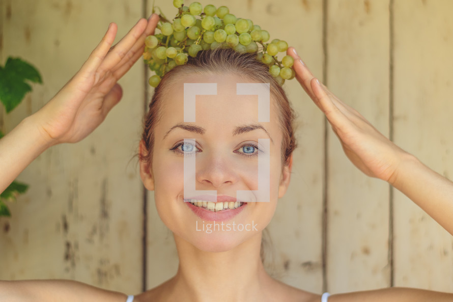a woman with grapes on her head 